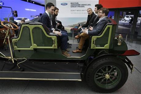 Visitors to the New York International Auto Show sit in an electric  carriage prototype in New York