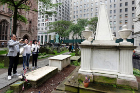 Visitors at the cemetery of Trinity Church photograph the grave of Alexander Hamilton, in New York's Financial District. Interest in historic sites associated with Hamilton has increased thanks to the hit Broadway musical “Hamilton.” 