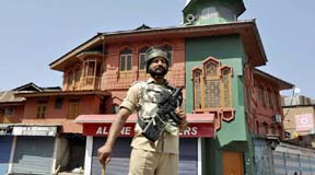 Srinagar: A security jawan, holding 'pellet gun', patrols on a deserted street during the 70th day of curfew in Srinagar on Friday. PTI Photo  (PTI9_16_2016_000256A)
