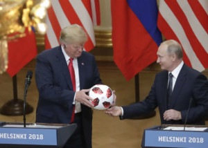 Russian President Vladimir Putin offers a ball of the 2018 FIFA World Cup to US President Donald Trump