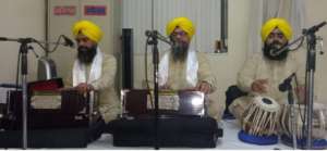 Trio singing bhajans during Baisakhi celebrations at Devon Gurdwara.