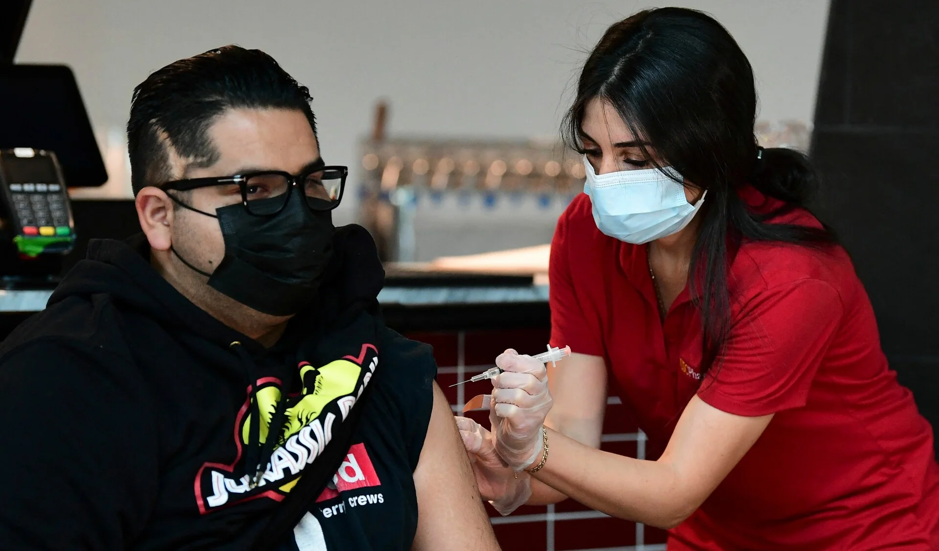 US-HEALTH-VIRUS Ricardo Sierra receives his Johnson & Johnson Covid19 vaccine administered by pharmacist Michelle Hormozia on May 7, 2021 in Los Angeles, California, at a vaccination clinic setup by Los Angeles Football Club, partnering with the LA county Department of Public Health and USC Pharmacy, where those vaccinated were due to receive a 20% discount on merchandise at the LAFC team store. - LA County public health officials are concerned about the considerable drop in countywide vaccination rates despite easier access for the free vaccine being offered with more no-appointment and walk-in vaccine clinics branching out to specific and targeted communities. (Photo by Frederic J. BROWN / AFP) (Photo by FREDERIC J. BROWN/AFP via Getty Images)