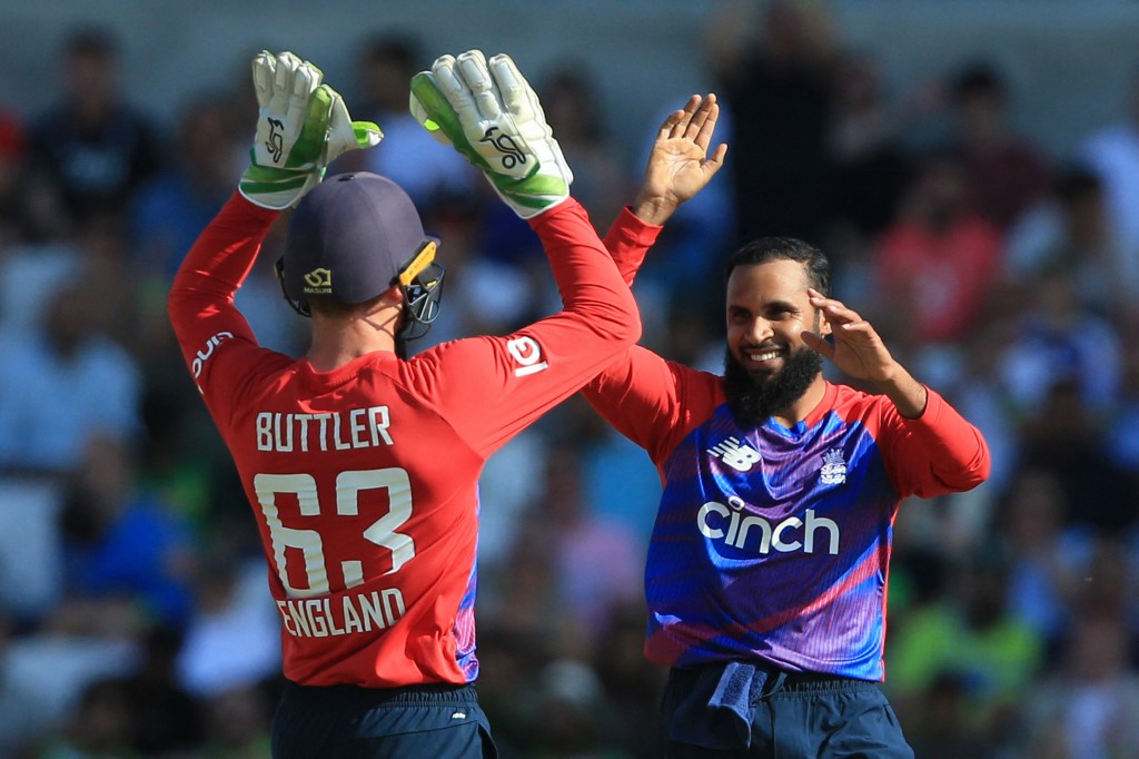 England's Adil Rashid (R) celebrates taking the wicket of Pakistan's Sohaib Maqsood during the second T20 international cricket match between England and Pakistan at Headingley Cricket Ground in Leeds, northern England, on July 18, 2021. (Photo by Lindsey Parnaby / AFP) / RESTRICTED TO EDITORIAL USE. NO ASSOCIATION WITH DIRECT COMPETITOR OF SPONSOR, PARTNER, OR SUPPLIER OF THE ECB