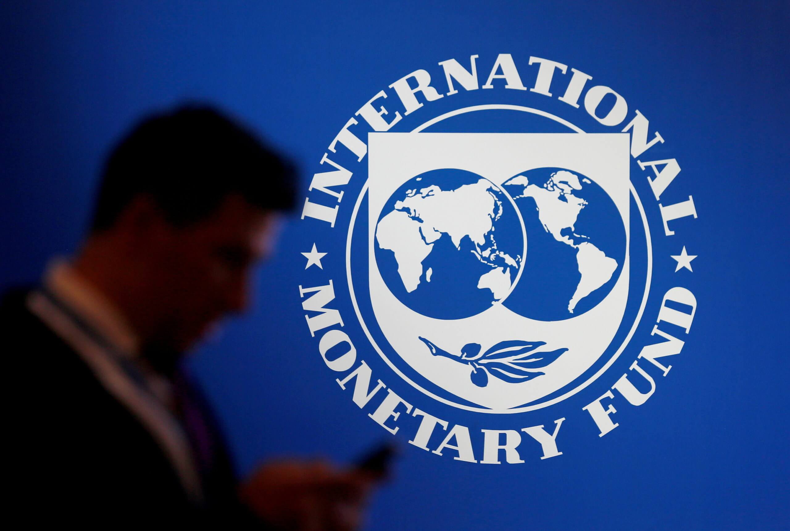 FILE PHOTO: A participant stands near a logo of IMF at the International Monetary Fund - World Bank Annual Meeting 2018 in Nusa Dua