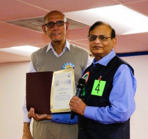 BSC Treasurer Sri MadarsangChavda giving Award Certificate to Talent participant Sri Jayanti Oza